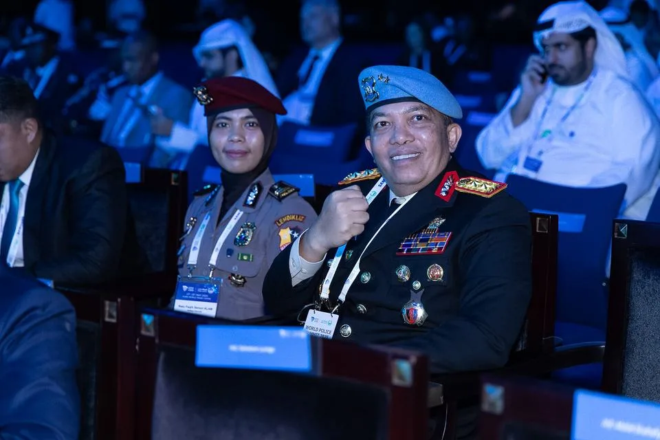 Two smiling police delegates seated in the WPS 2025 audience