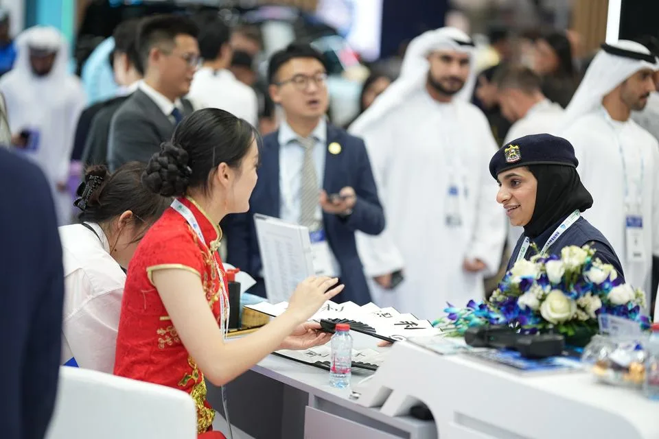 Visitors and a police officer networking at a stand at WPS 2025